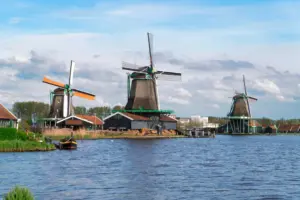 Traditional,dutch,windmills,of,zaanse,schans,over,water,at,summer